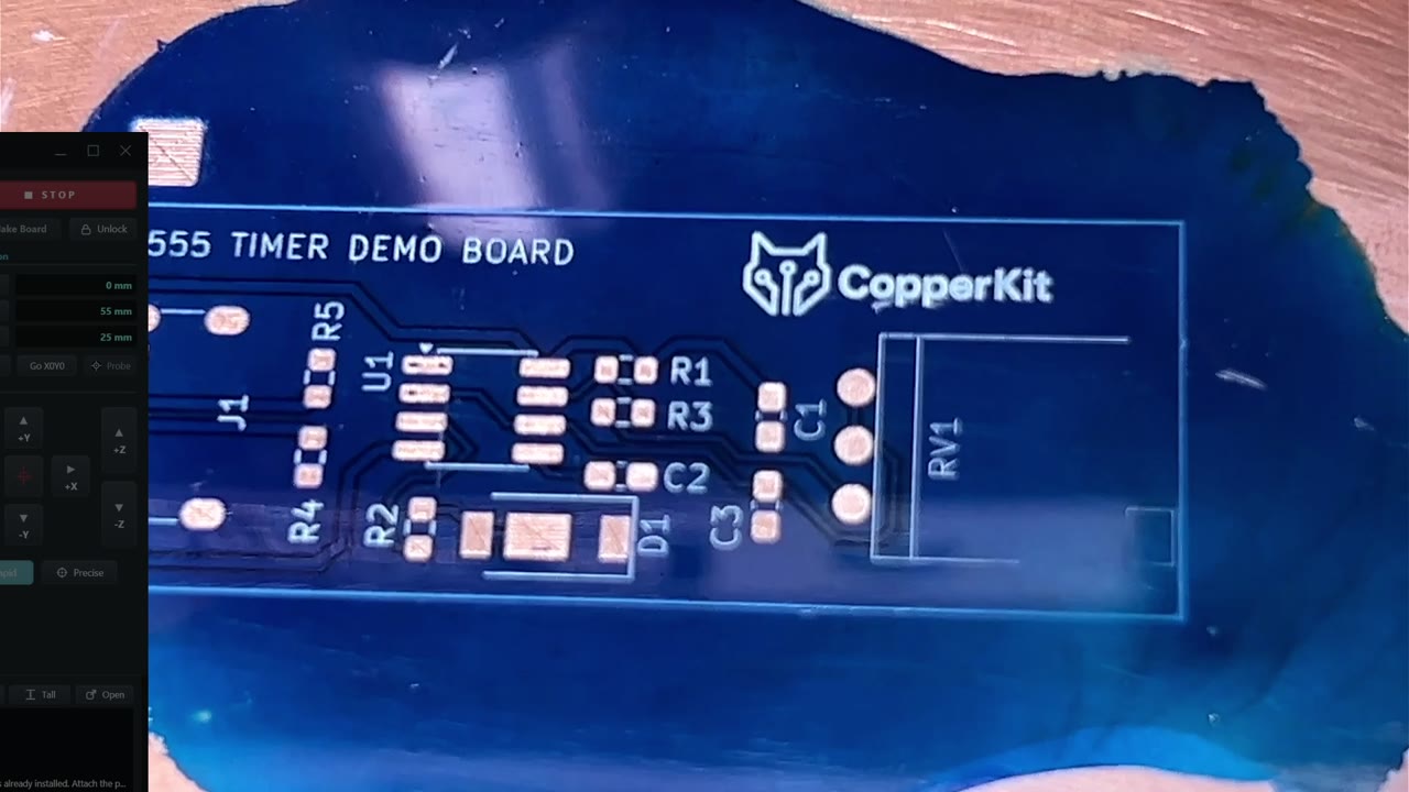 The blue 555 timer board with exposed copper pads and white component markings.