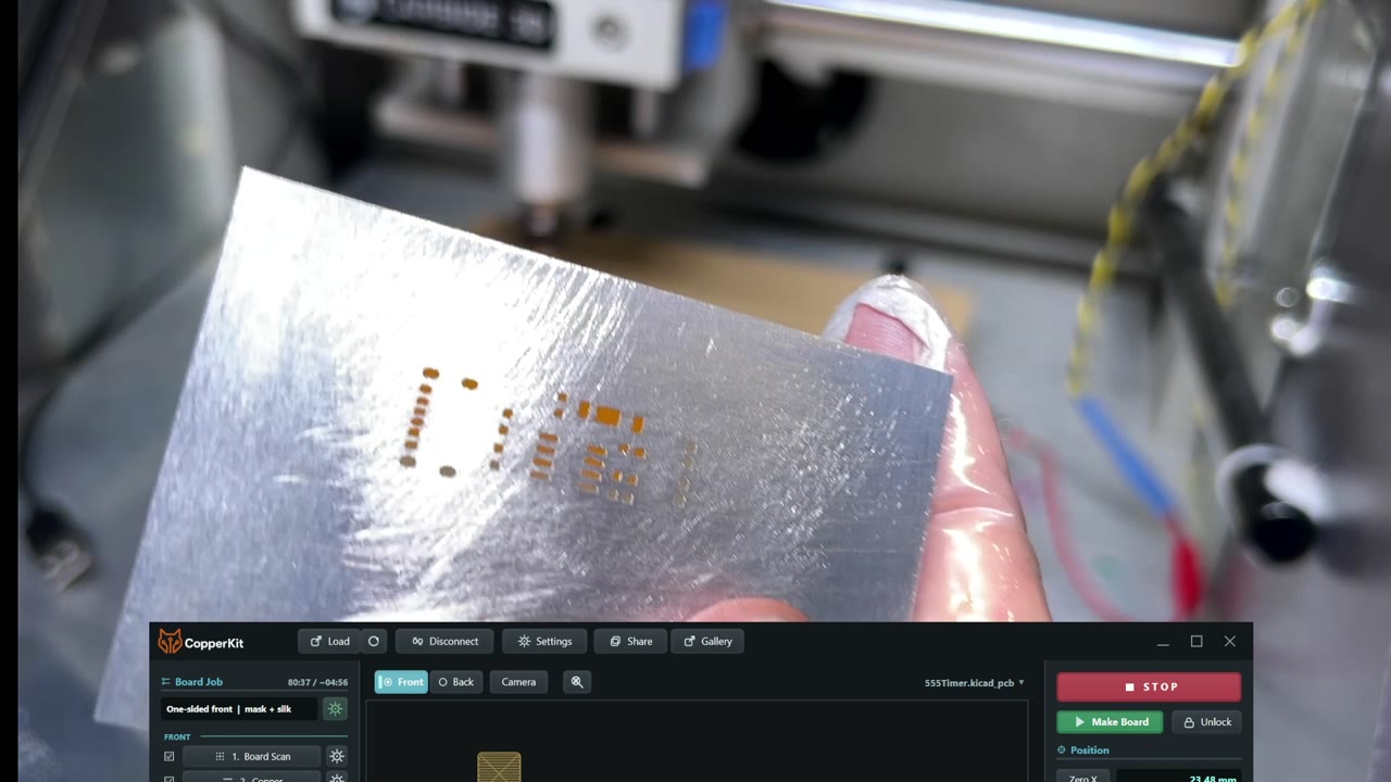 The finished aluminum stencil held up to show the openings for the 555 board's pads.